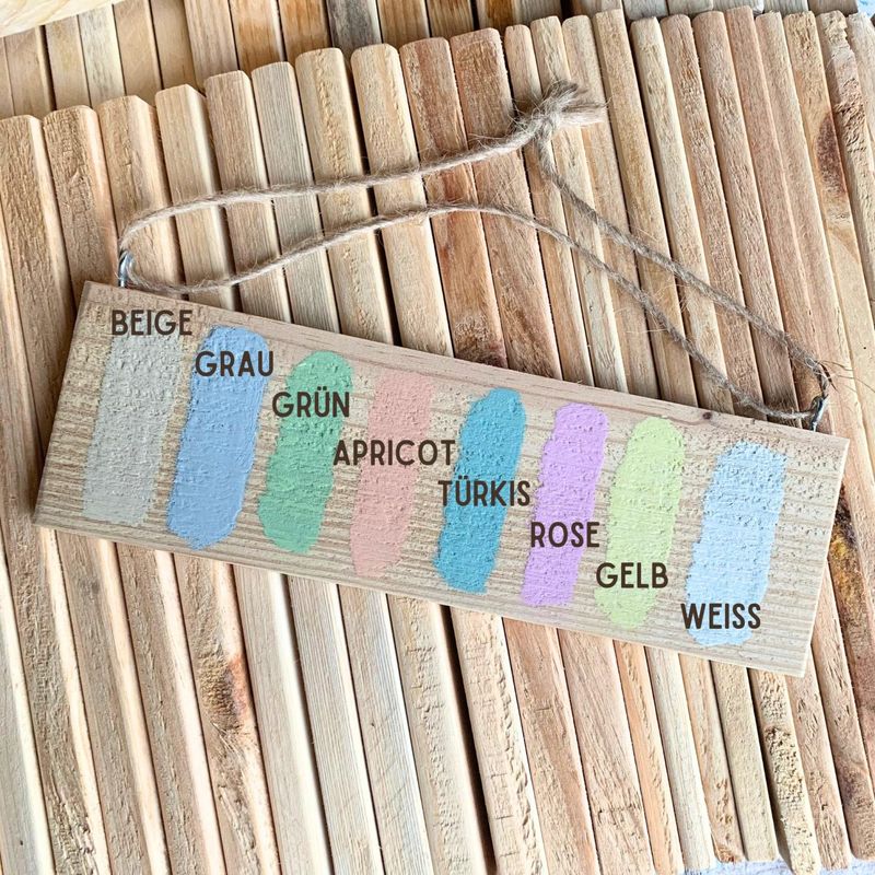 Musterbrett mit acht aufgetragenen Farbtönen: Beige, Grau, Grün, Apricot, Türkis, Rosé, Gelb und Weiß