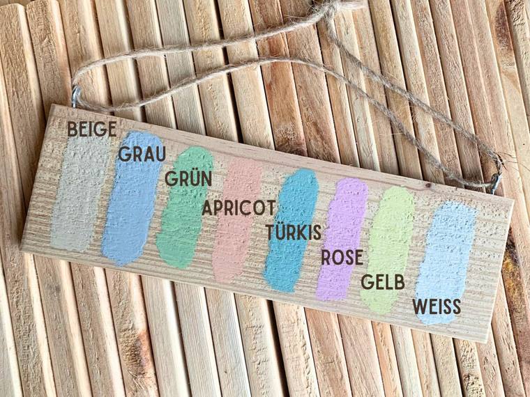 Musterbrett mit acht aufgetragenen Farbtönen: Beige, Grau, Grün, Apricot, Türkis, Rosé, Gelb und Weiß