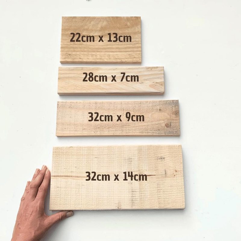 Vier unbearbeitete Palettenholzbretter in den Größen 22 × 13, 28 × 7, 32 × 9 und 32 × 14 Zentimeter nebeneinander