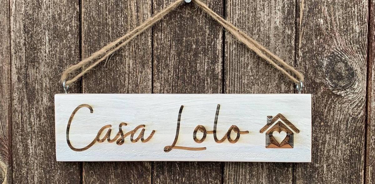 Weiß gestrichenes Türschild aus Palettenholz mit dem gebrannten Schriftzug Casa Lolo