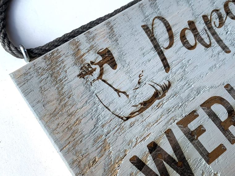Nahaufnahme der eingebrannten Schrift Papas Werkstatt auf grau lasiertem Altholz